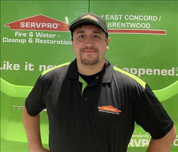 Male employee in front of green truck