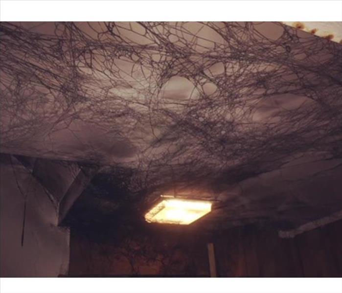 Cobwebs on a ceiling damaged by smoke 